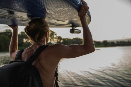 ©SCUBAJET Man carrying a SUP with a mounted SCUBAJET